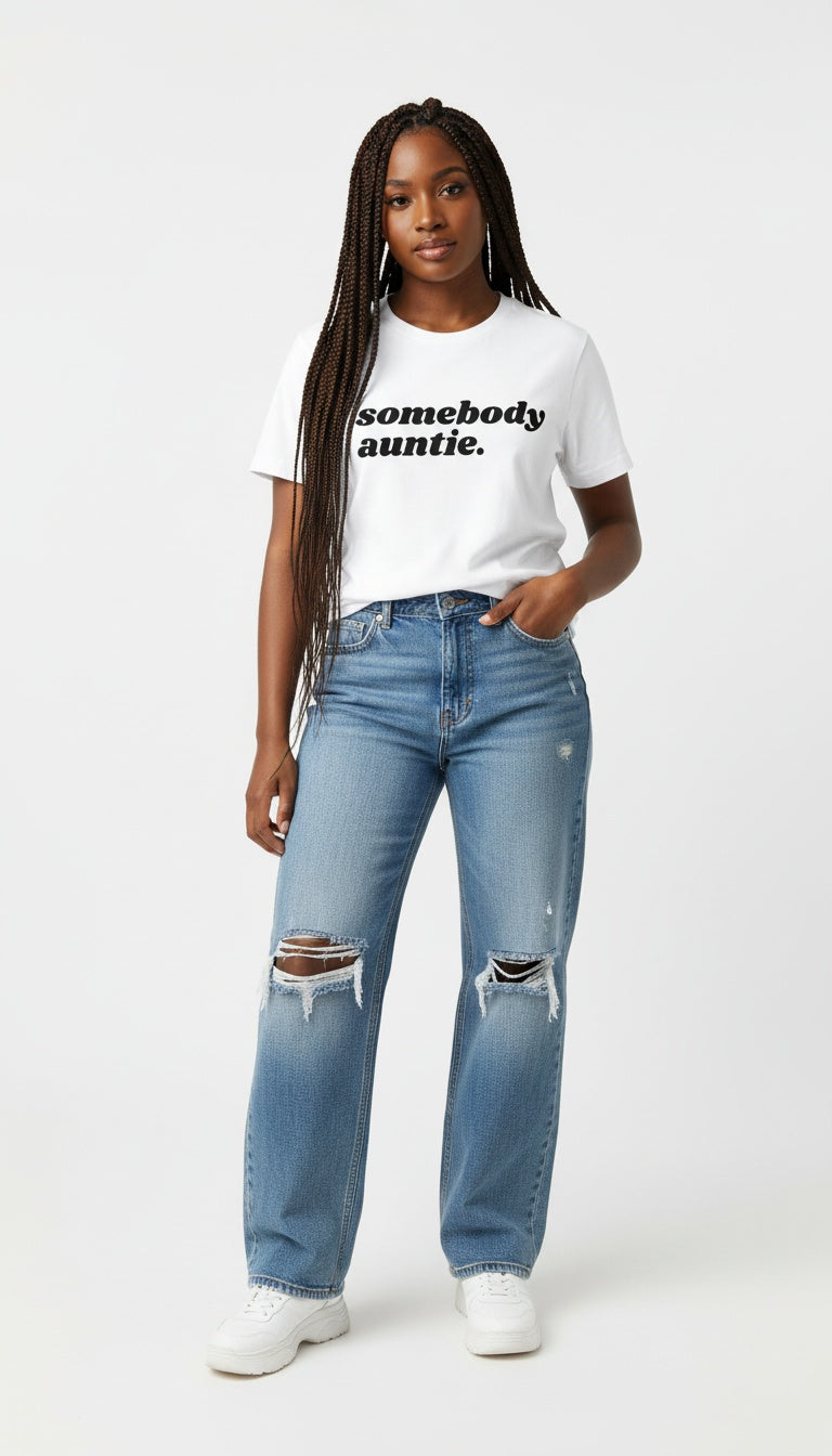 Person wearing a white t-shirt with text and light blue jeans on a white background